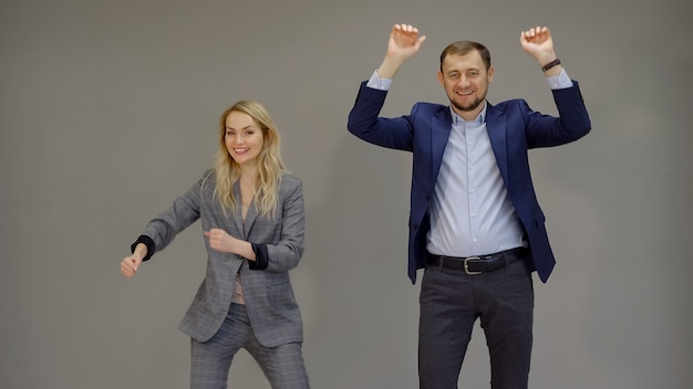 Los socios comerciales están bailando, marcando un acuerdo exitoso sobre un fondo gris aislado.