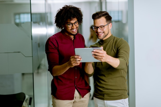 Foto socios comerciales multiétnicos que usan una tableta digital en la oficina