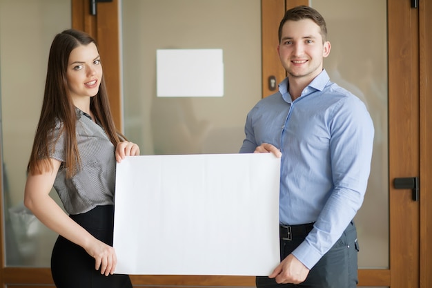 Socios comerciales trabajando juntos y sosteniendo carteles en blanco