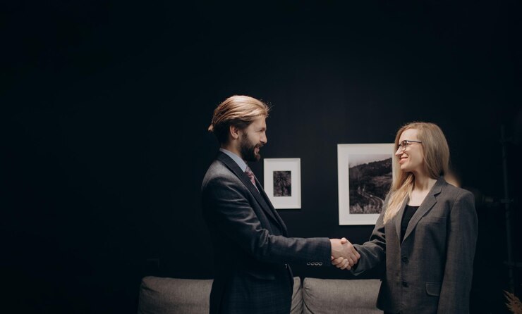 Socios comerciales en traje formal estrechando la mano en la oficina