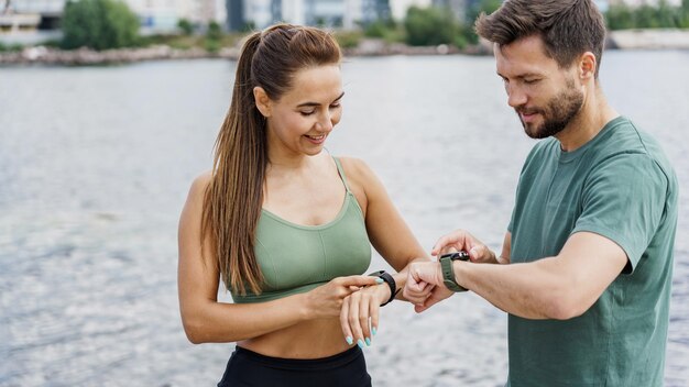 Foto socios de fitness sincronizan relojes inteligentes centrándose en el seguimiento del rendimiento
