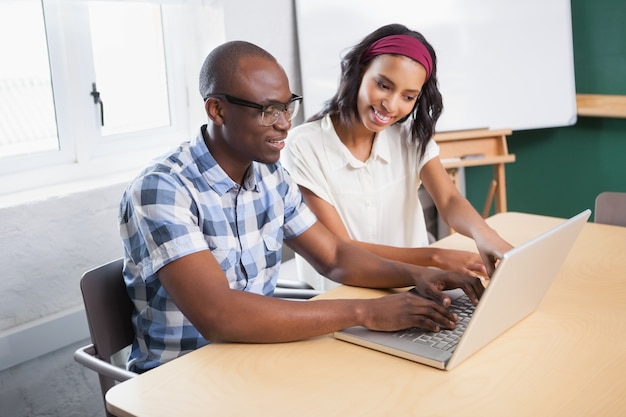 Socios que trabajan en el escritorio usando la computadora portátil