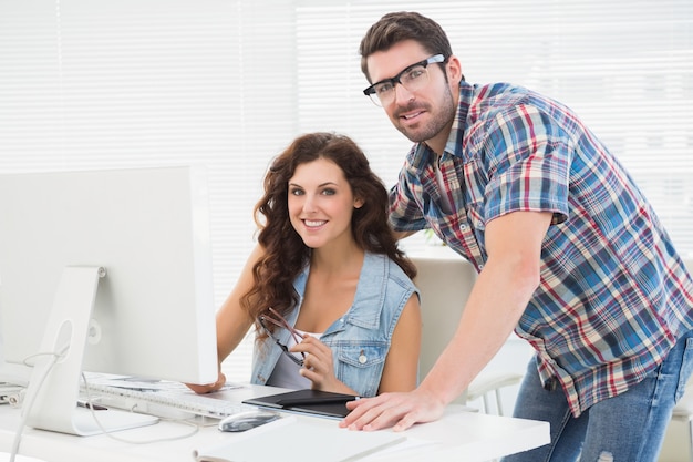 Socios sonrientes que usan la computadora junto