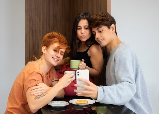 Socios sonrientes de tiro medio tomando selfie