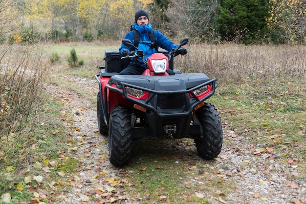 Socorrista inspecionando a área da floresta por quadriciclo ATV