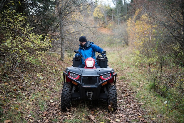 Socorrista inspecionando a área da floresta por quadriciclo ATV