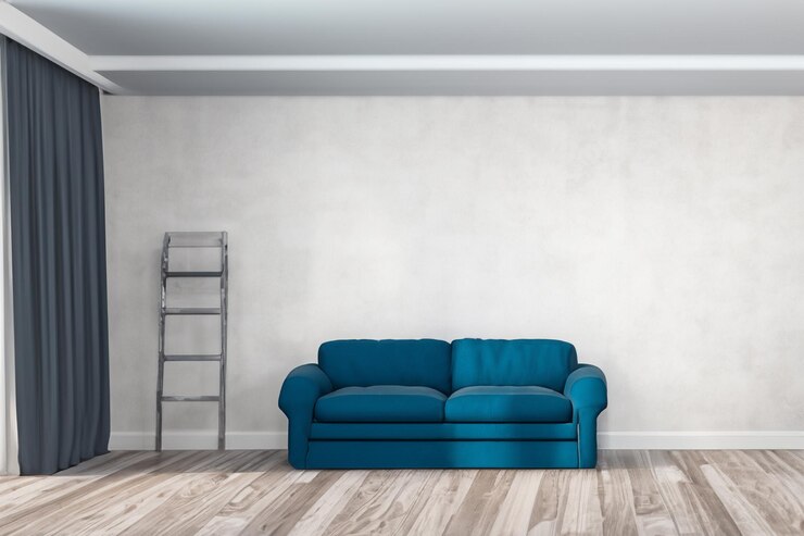 un sofá azul se sienta en una habitación con una escalera apoyada contra la pared