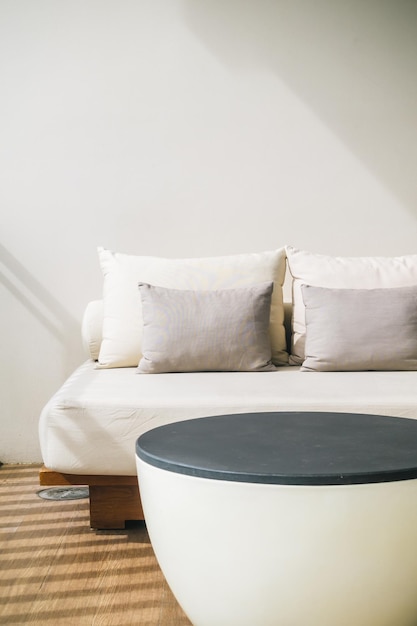 Sofa branca com almofadas contra a parede em casa