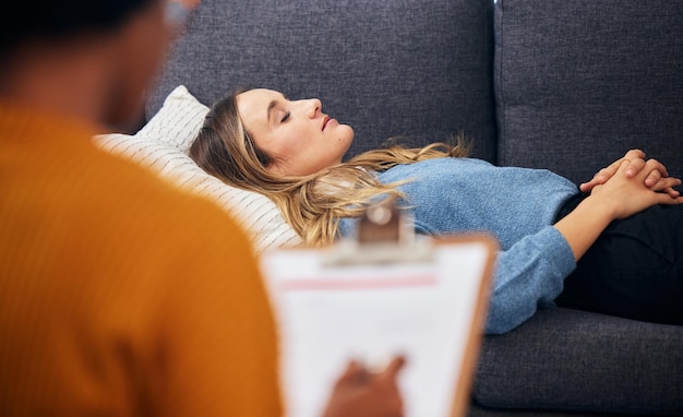 Sofá de terapia e mulher relaxam em aconselhamento para saúde mental, ajuda para depressão e ouve comunicação Consulta de psicólogo e paciente deitado no sofá escrevendo notas e conforto para dormir