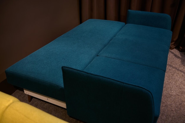 Sofá elegante azul escuro e verde em uma forma dobrável em exposição em uma loja de móveis Conceito de design de interiores para casa
