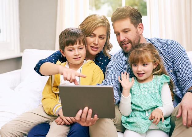 Sofa familiar e tablet em casa para streaming de chamadas de vídeo e filme com site de internet e onda Parentes de tecnologia e crianças na sala de estar para filme relaxar e jogar jogo no fim de semana no sofá