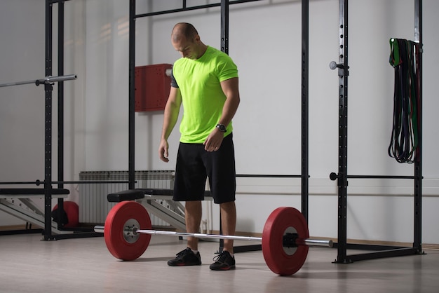 Sofá haciendo ejercicio de peso pesado para la espalda con pesas en el gimnasio