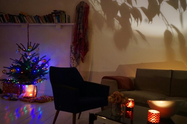 Sofa junto al árbol de Navidad iluminado en casa