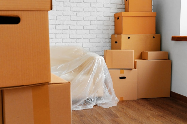 Sofá lleno y pila de cajas de cartón en un concepto de movimiento de habitación