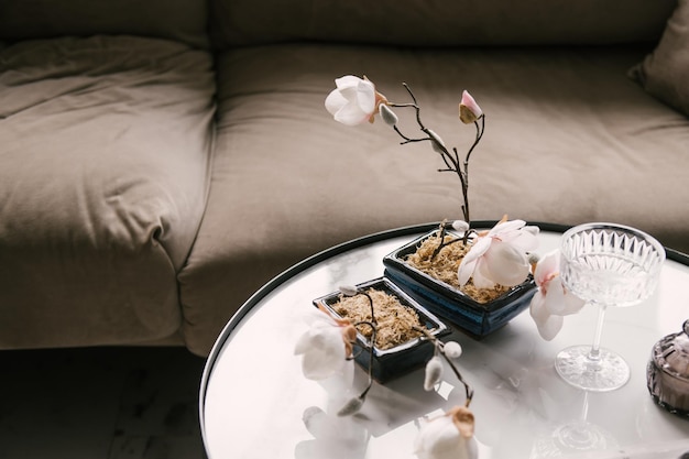 Sofá moderno y elegante en el interior con mesa de centro de mármol y flores.