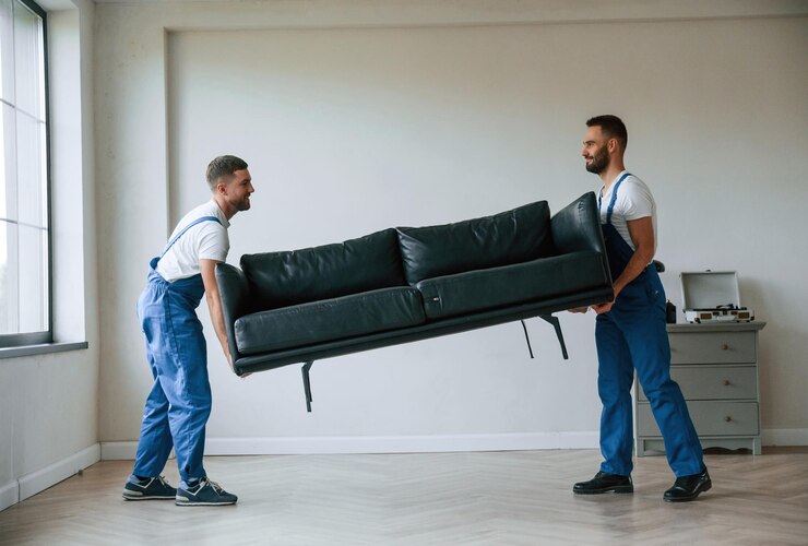 Foto sofa nas mãos dois funcionários do serviço de mudança num quarto