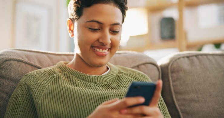 Foto sofá de la sala de estar smartphone scroll o persona leyendo artículo de blog o comunicación manos de teléfono en el hogar o mujer feliz relajarse sonreír y escribir búsqueda en línea experiencia del cliente revisión y comprobación de la aplicación