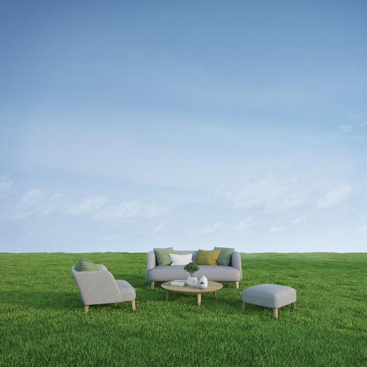 Sofá sillón y mesa en pradera verde con fondo de cielo azul