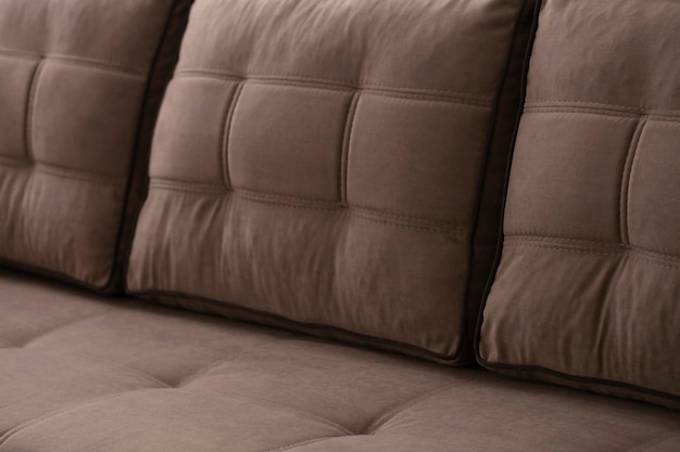 Foto sofá suave de beigebrown acolchado con cojines de terciopelo cosidos mobiliario con reposabrazos