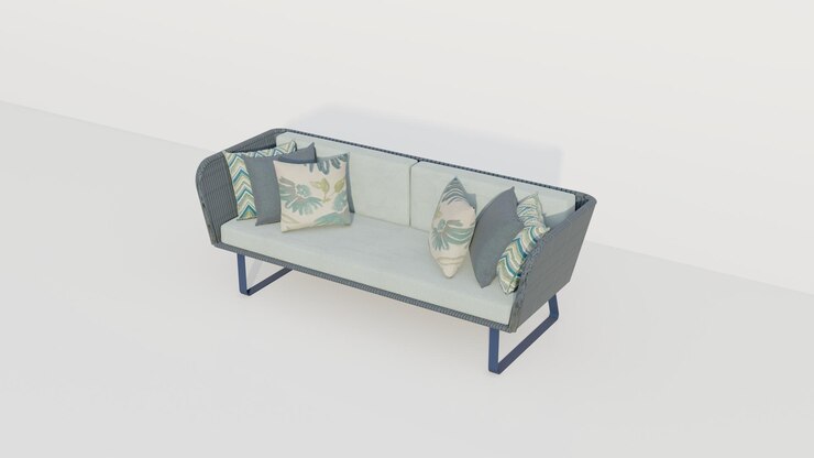 Foto sofá de terciopelo verde pastel con almohadas grises y tropicales en el fondo