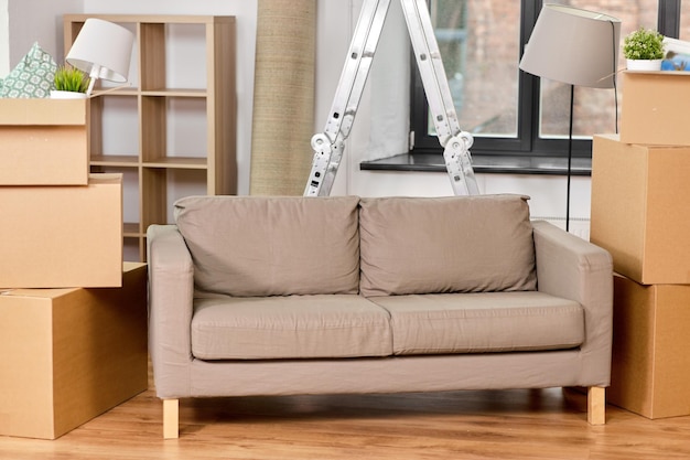 Sofa und Wellkarton mit Sachen im neuen Zuhause