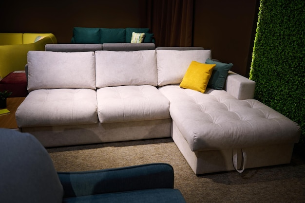 Sofás modernos e elegantes sofás com almofadas coloridas brilhantes de tecidos de alta qualidade exibidos para venda no showroom da loja de móveis