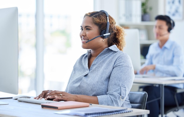 Sofortige Sprach-, Chat- und E-Mail-Unterstützung. Aufnahme eines jungen Call-Center-Agenten, der in einem Büro an einem Computer arbeitet.