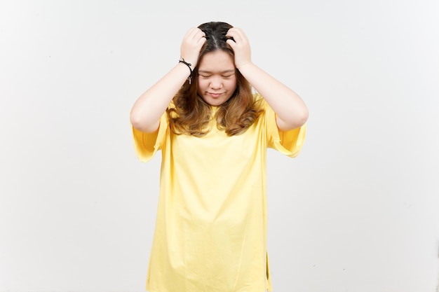 Sofrendo dor de cabeça de linda mulher asiática vestindo camiseta amarela isolada em fundo branco