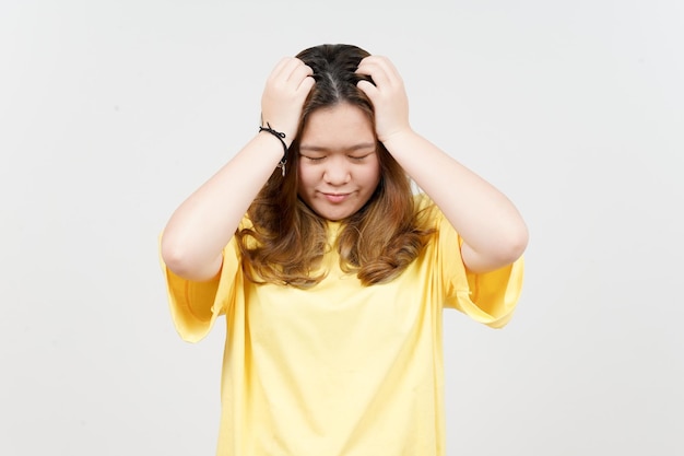 Sofrendo dor de cabeça de linda mulher asiática vestindo camiseta amarela isolada em fundo branco