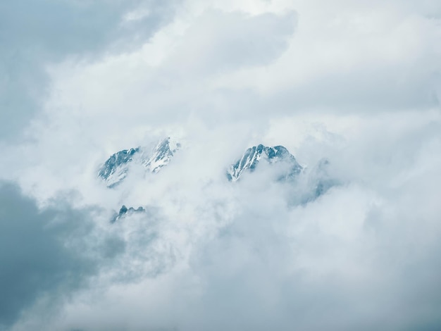 Soft-Fokus Minimalistische Berglandschaft Wunderbare minimalistische Landschaft mit großen schneebedeckten Berggipfeln über niedrigen Wolken Atmosphärischer Minimalismus mit großen schneebedeckten Berggipfeln in bewölktem Himmel