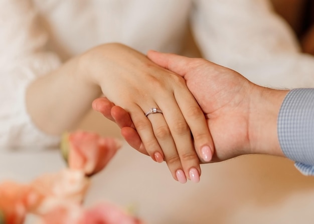 Foto softfocus primer plano hombre caucásico sosteniendo la mano de la mujer con anillo de diamantes