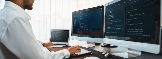 Software-Ingenieur, der an der Entwicklung von Anwendungen an seinem Computer arbeitet, zeigt Code und Skript auf dem Monitor am Arbeitsplatz im Büro eines Tech-Unternehmens. Anwendungsentwickler, der Code löst und schreibt