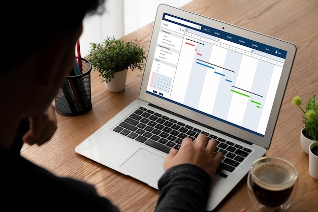 Foto software de planificación de proyectos para la gestión de proyectos empresariales modish en la pantalla de la computadora que muestra el gráfico de línea de tiempo del proyecto del equipo