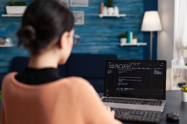 Software de programación independiente en portátil. Programador que trabaja a distancia desde la oficina en casa. Depuración del probador de código en la computadora portátil usando el teclado. Estudiante desarrollador escribiendo datos en la pantalla.
