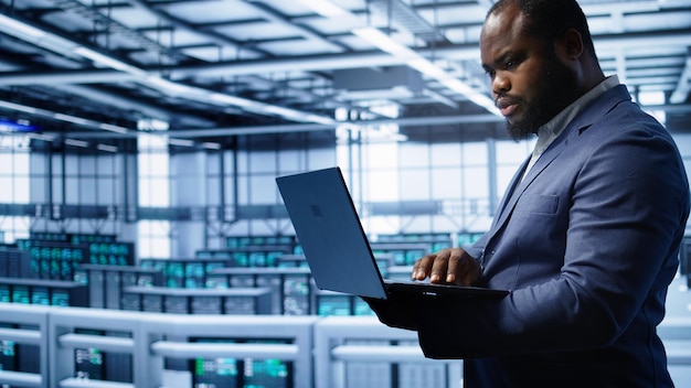 Softwareentwickler überwacht den Energieverbrauch von Server-Hub-Hardware mit Laptop