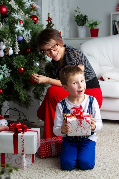 Sohn mit Mutter am Weihnachtsbaum.