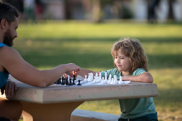 Sohn spielt Schach mit Vater im Park