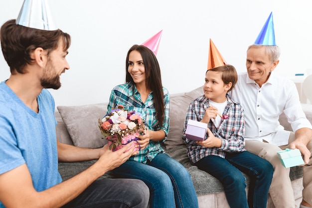 Sohn und Schwiegervater gratulieren Mutter zum Geburtstag.