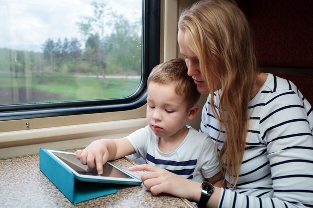 Sohn und seine Mutter mit Tablet-PC im Zug