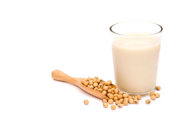 Foto soja en cuchara de madera y vaso de leche de soja aislado sobre fondo blanco.