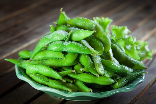 Soja japonesa no prato verde na mesa de madeira