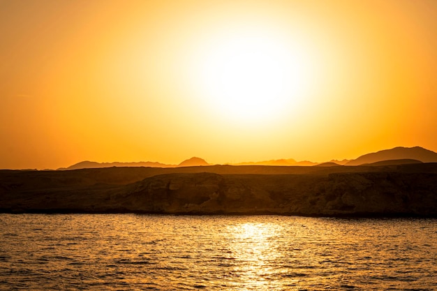 Sol amarillo brillante en el cielo Hermosa puesta de sol amarilla en el mar rojo