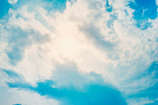 Sol atrás das nuvens no céu azul em dia de verão.