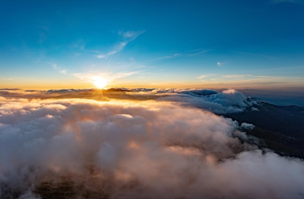 El sol brilla intensamente sobre las nubes blancas y esponjosas al amanecer.