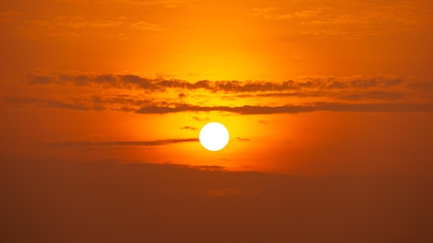 El sol brilla y las nubes en el cielo anaranjado cambiante de la mañana