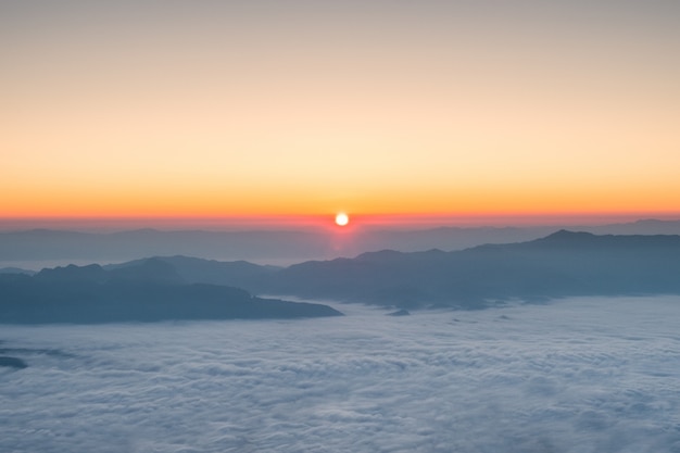 El sol brilla sobre el horizonte con la montaña