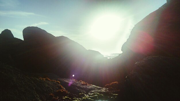 Foto el sol brilla a través de las montañas