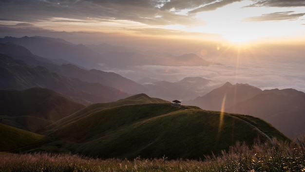 El sol brilla a través de las nubes sobre las montañas