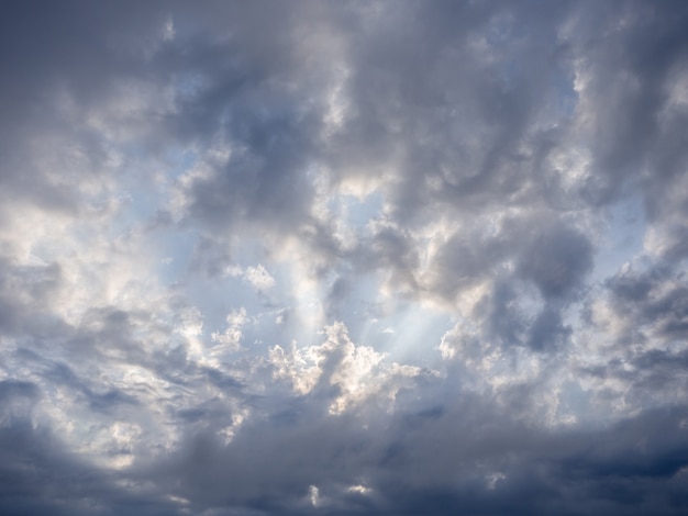 Sol brillante en el cielo azul con nubes oscuras