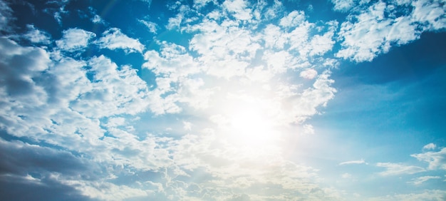 sol brillante con destello de lente. Cielo azul con fondo de nubes